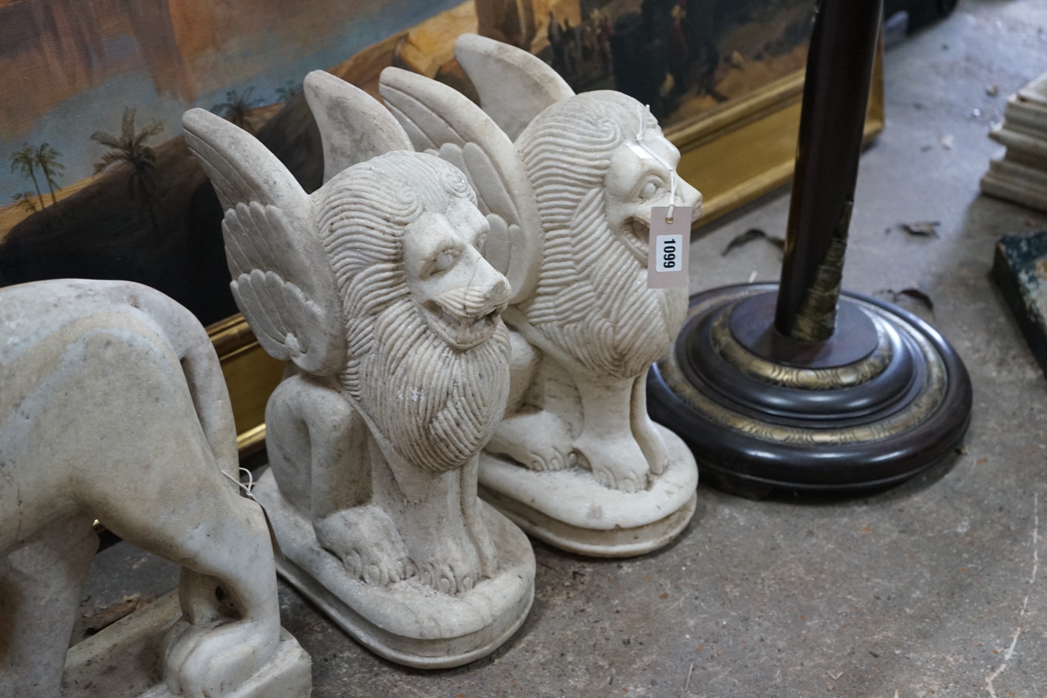 A pair of South East Asian carved stone winged lions, height 40cm